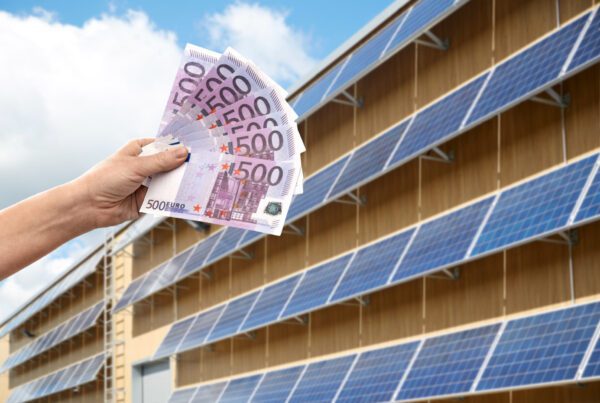 duurzaam zonnepanelen huren wordt gesymboliseerd door hand die geld vasthoudt langs een dak met zonnepanelen.