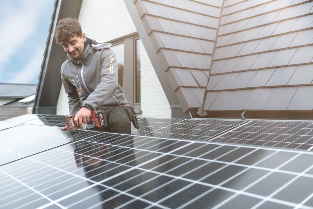 Technieker van Futech installeert zorgvuldig een zonnepaneel op het dak, illustrerend de deskundige installatieservice bij het kopen van zonnepanelen via Futech.